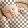 Sleeping Baby Wearing A Checkered Hat And Outfit.