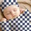 Sleeping Baby Wearing A Navy And White Checkered Hat And Outfit.