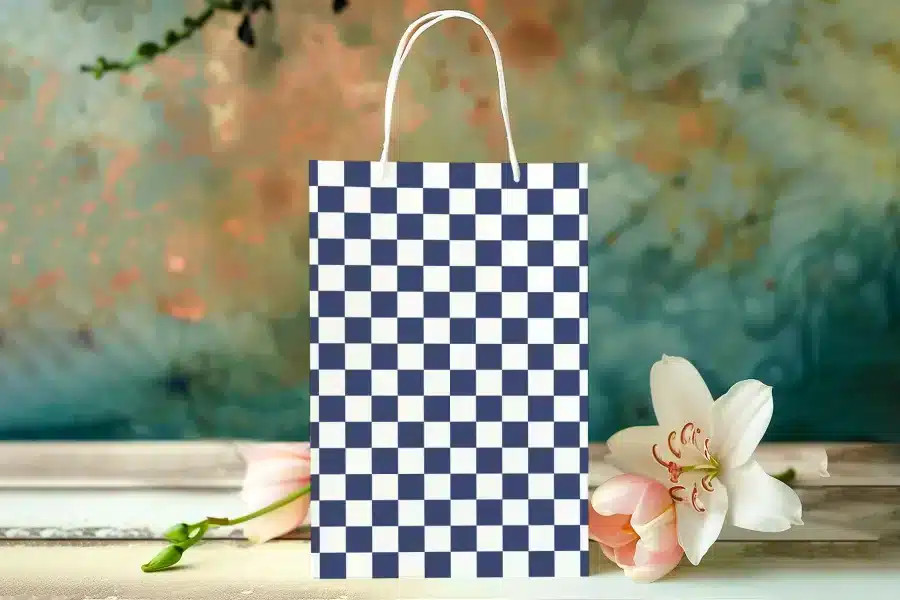 A Navy Blue And White Checkered Gift Bag With White Handles.