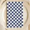 A Navy Blue And White Checkered Napkin On A Beige Plate.