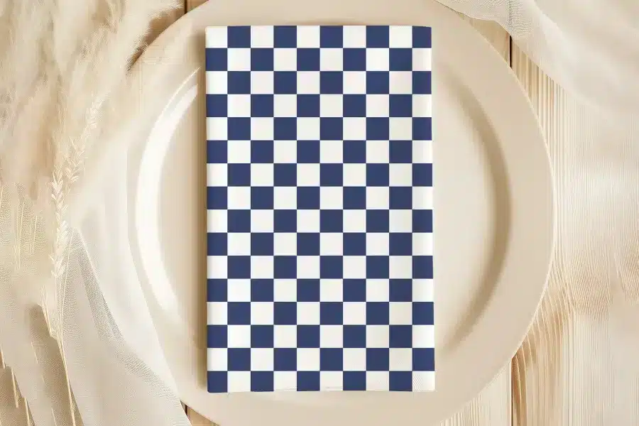 A Navy Blue And White Checkered Napkin On A Beige Plate.