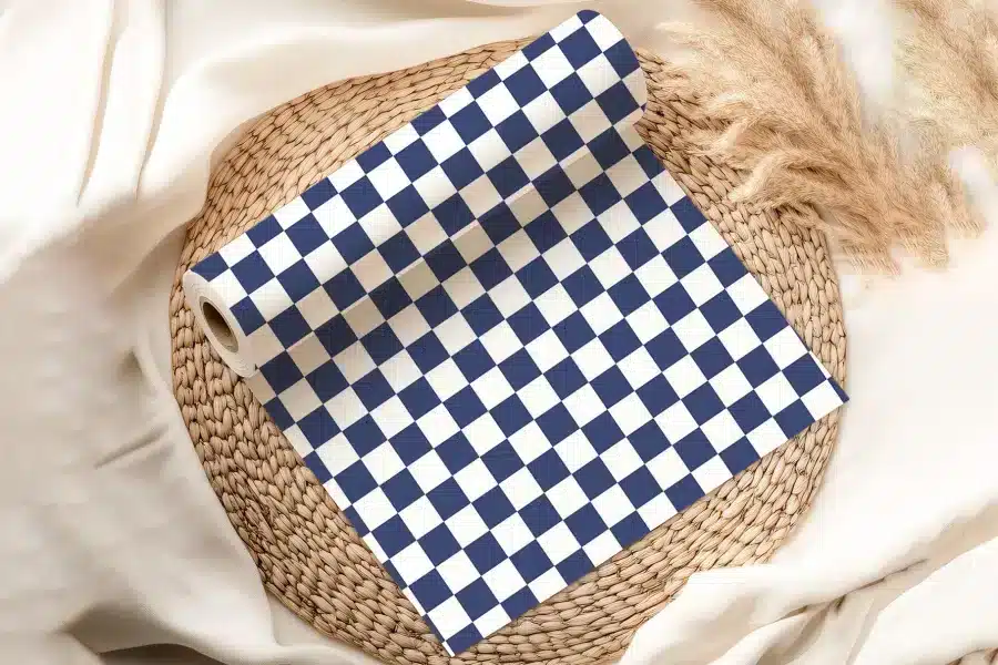 A Roll Of Navy Blue And White Checkered Wrapping Paper On A Woven Mat.