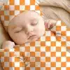 Sleeping Baby Wearing An Orange And White Checkered Outfit.