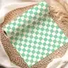 A Roll Of Mint Green And White Checkered Paper On A Woven Mat.