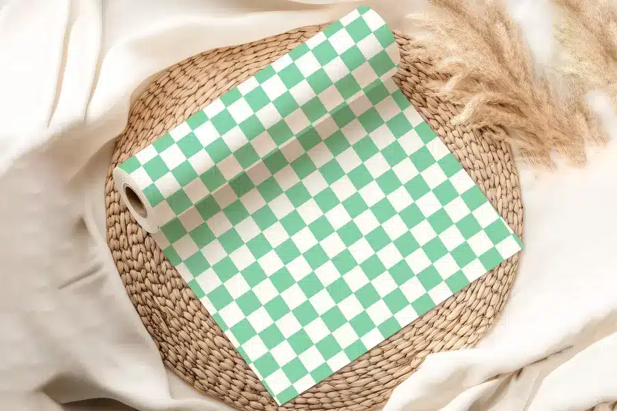 A Roll Of Mint Green And White Checkered Paper On A Woven Mat.