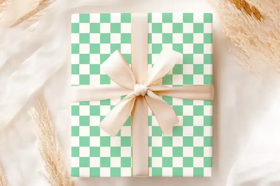 Gift Box With Light Green And White Checkered Pattern And A Beige Ribbon.