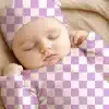 Sleeping Baby Wearing A Lavender And White Checkered Onesie And Hat.