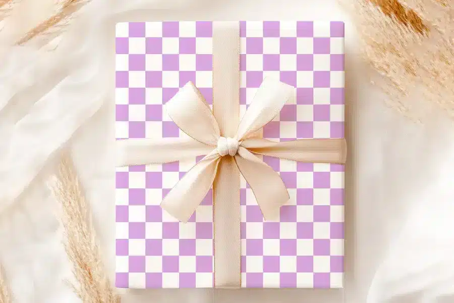 A Gift Box With A Lavender And White Checkered Pattern And A Beige Ribbon.