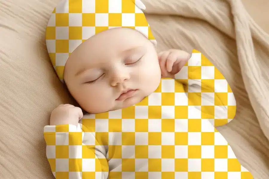 Sleeping Baby Wearing A Yellow And White Checkered Hat And Outfit.