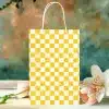 Yellow Checkered Paper Shopping Bag On A Table With Flowers.