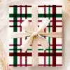 A Gift Wrapped In Cream-Colored Paper With A Red, Green, And Black Plaid Pattern And Tied With A Beige Ribbon.