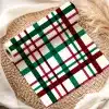 Roll Of Red, Green, And Black Plaid Wrapping Paper On A Woven Placemat.
