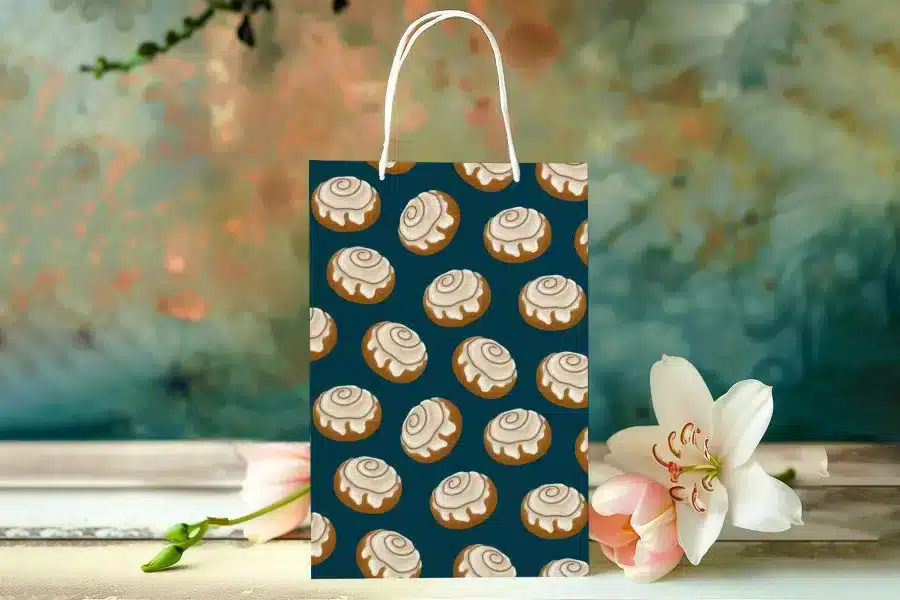 Gift Bag With A Teal Background And A Repeating Pattern Of Cinnamon Rolls.
