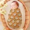 Sleeping Baby Swaddled In A Cinnamon Roll Patterned Wrap.