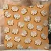 A Tan Throw Pillow With A Repeating Pattern Of Cinnamon Rolls.