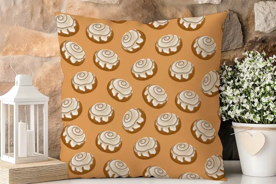 A Tan Throw Pillow With A Repeating Pattern Of Cinnamon Rolls.
