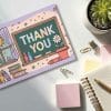 Thank You Card Featuring A Chalkboard With The Words Thank You, Classroom Items, And A Sun.