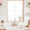 A Bright Kitchen Sink With A Gold Faucet, Flanked By Wooden Shelves Holding Dishes And Plants.  A Loaf Of Bread Sits On A Cutting Board On The Counter.