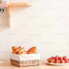 A Wicker Basket Of Croissants Sits On A Wooden Table Next To A Plate Of Strawberries.