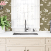 Kitchen Sink And Countertop With Light Wood Cabinets, A Plant, And A Bottle Of Wine.
