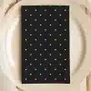 Black Napkin With White Polka Dots On A Beige Plate.