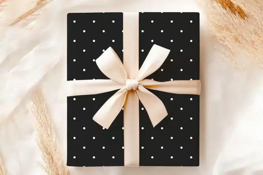 Black Gift Box With White Polka Dots And A Beige Ribbon.
