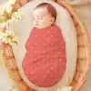 Sleeping Baby Swaddled In A Coral-Colored, White Polka Dot Wrap.