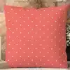 Coral-Colored Pillow With A White Polka Dot Pattern.