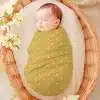 Sleeping Baby Swaddled In A Mustard Yellow Polka Dot Wrap.