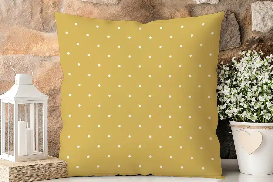 Mustard Yellow Square Pillow With A White Polka Dot Pattern.