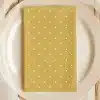 Mustard Yellow Napkin With White Polka Dots On A White Plate.