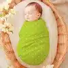 Sleeping Baby Swaddled In A Lime Green Polka Dot Wrap.