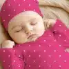 Sleeping Baby Wearing A Pink Polka Dot Hat And Outfit.