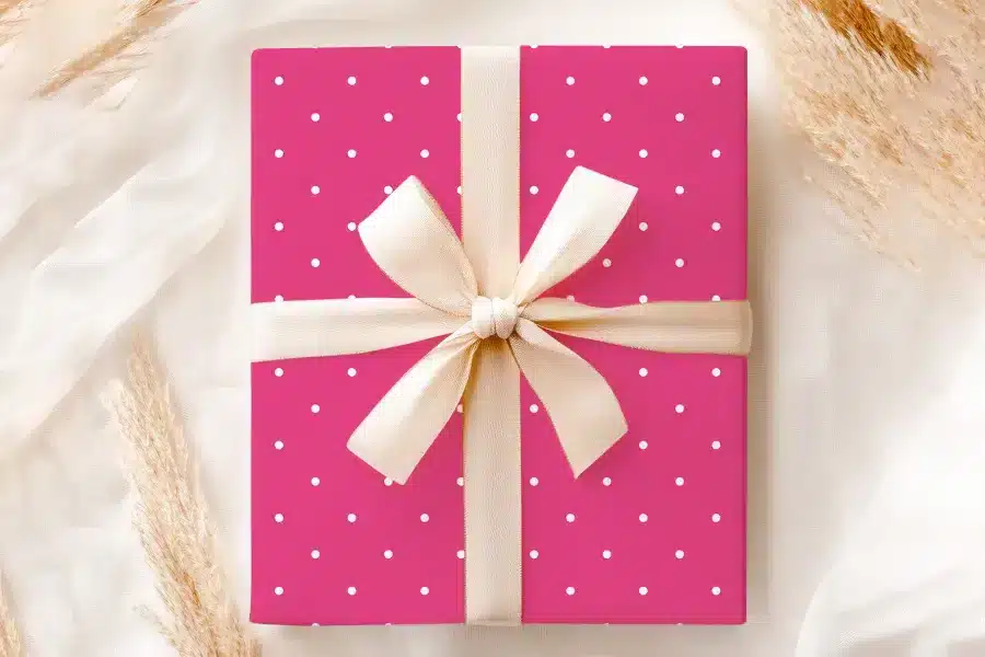 Pink Gift Box With White Polka Dots And A Beige Ribbon.