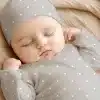Sleeping Baby Wearing A Gray Polka Dot Hat And Outfit.