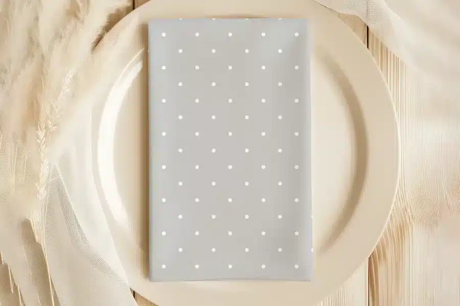 Gray Napkin With White Polka Dots On A Beige Plate.