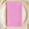 Pink Napkin With White Polka Dots On A Beige Plate.