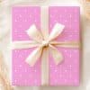 Pink Gift Box With White Polka Dots And A Beige Ribbon Tied In A Bow.