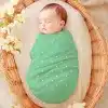 Sleeping Baby Swaddled In A Mint Green Polka Dot Blanket.