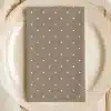 Beige Napkin With White Polka Dots On A Beige Plate.