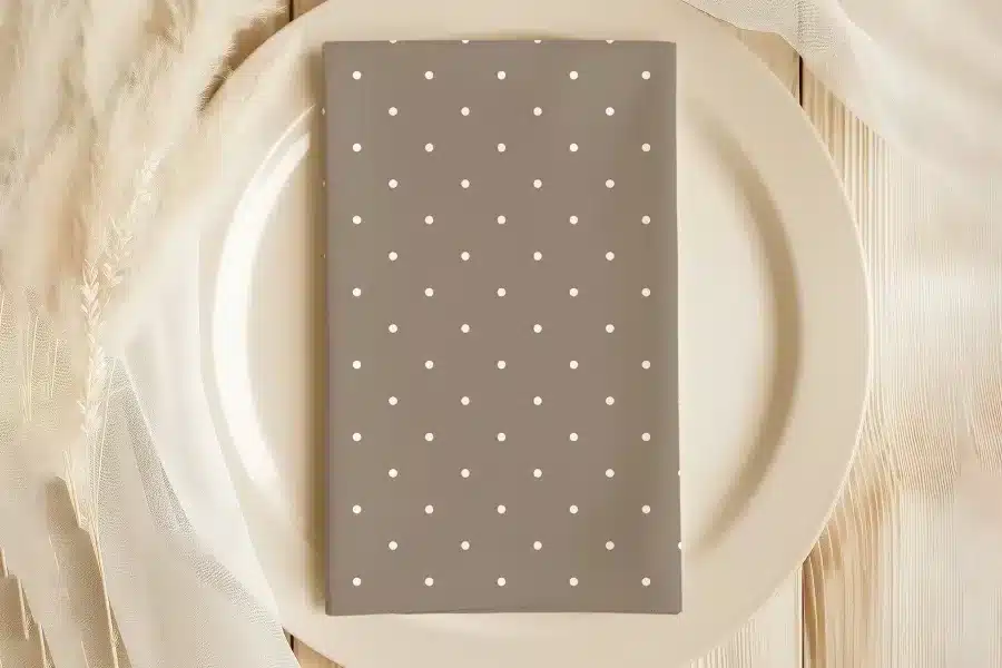 Beige Napkin With White Polka Dots On A Beige Plate.