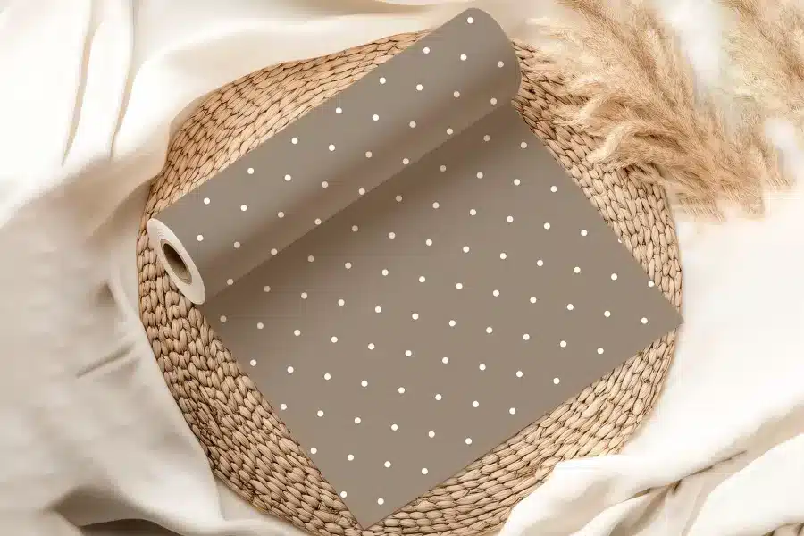 A Roll Of Taupe Wrapping Paper With White Polka Dots.