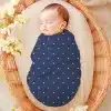 Sleeping Baby Swaddled In A Navy Blue Polka Dot Blanket.