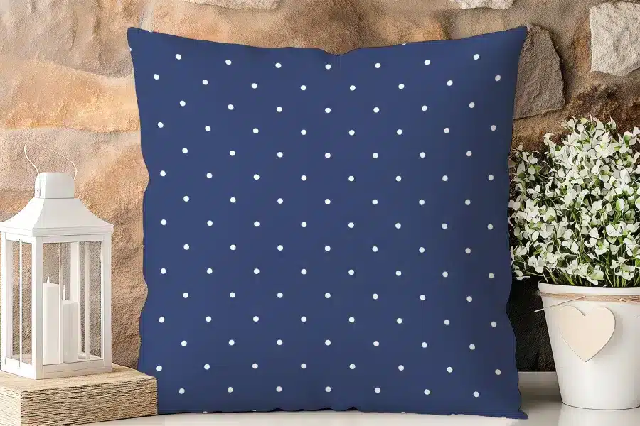 Navy Blue Pillow With A White Polka Dot Pattern.