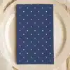 Navy Blue Napkin With White Polka Dots On A Beige Plate.