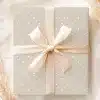 A Light Beige Gift Box With White Polka Dots And A Beige Ribbon Tied In A Bow.