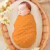 Sleeping Baby Swaddled In An Orange Polka Dot Wrap Inside A Wicker Basket.