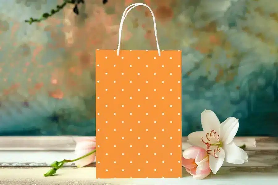 Orange Polka Dot Gift Bag With White Handles.