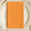 Orange Napkin With White Polka Dots On A White Plate.
