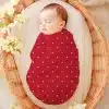 Sleeping Baby Swaddled In A Red Polka Dot Wrap.